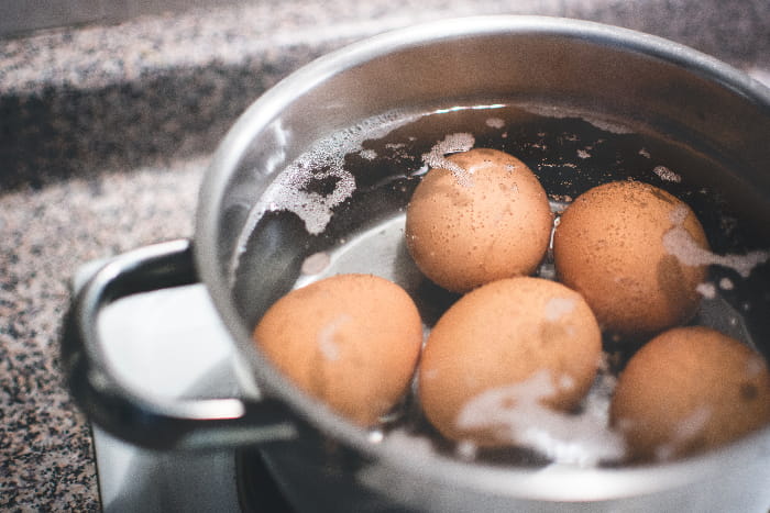 five eggs boiling in the pot on stovetop