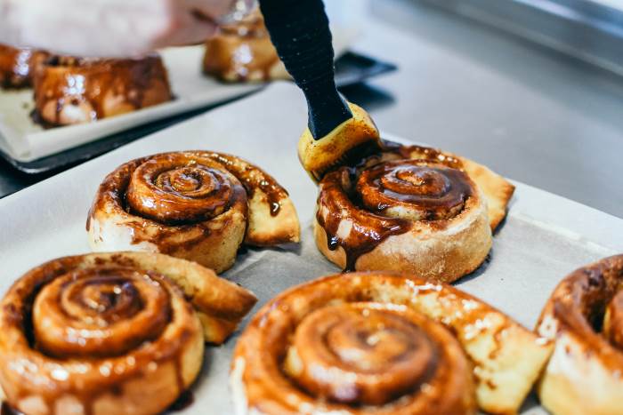 covering cinnamon rolls with glaze