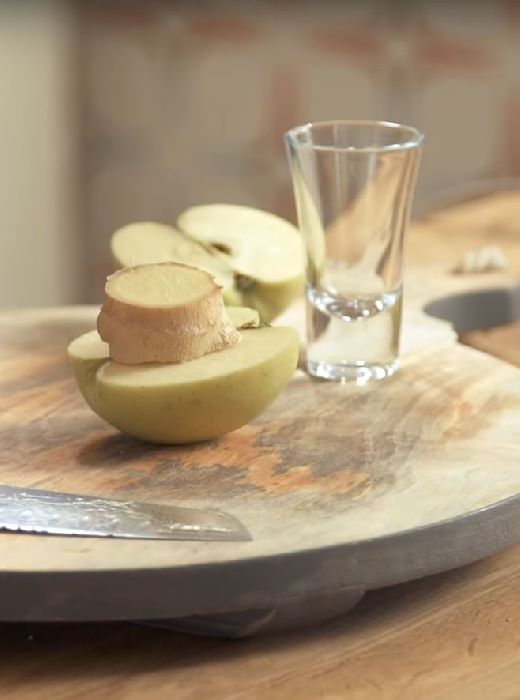 pieces of ginger and apple and a shot glass