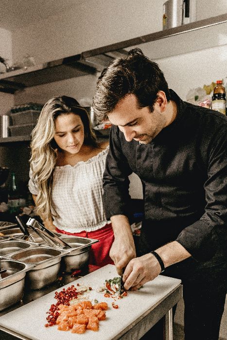 young man teaches young woman how to cook