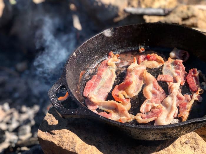 4 curly strips of bacon in cast iron pan